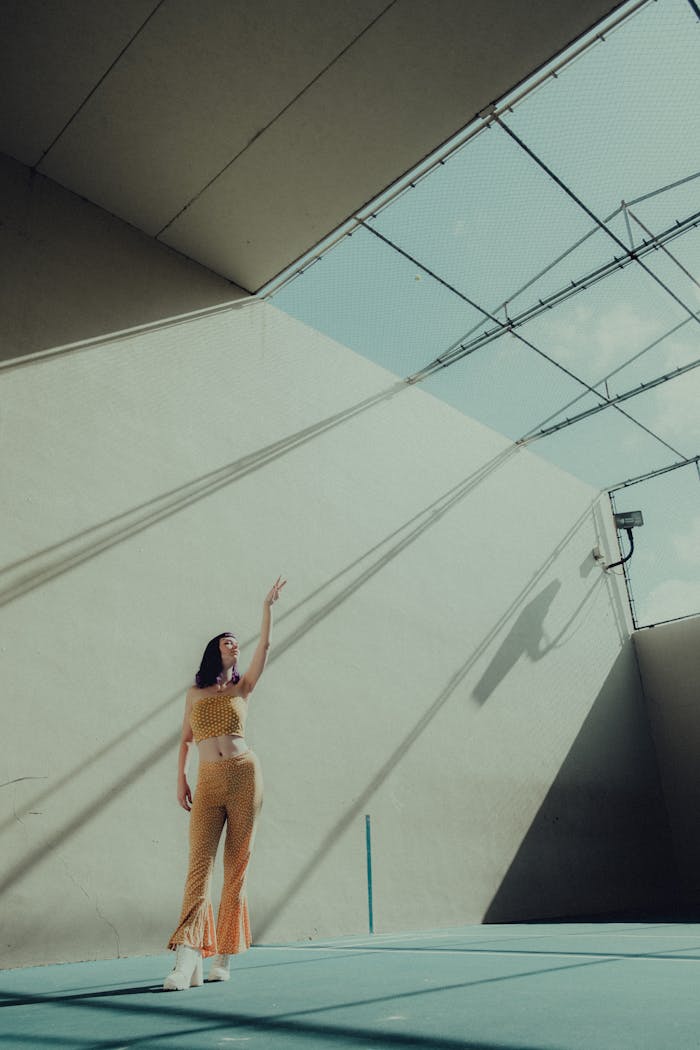 A fashionable woman in a geometric space, accented by strong sunlight and shadows.